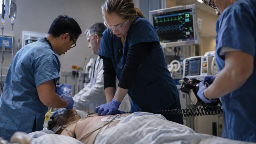 Soignants réalisant une réanimation cardio-pulmonaire autour d’un patient